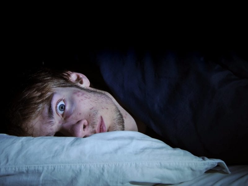 Man in bed with eyes open suffering insomnia